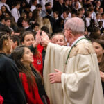 Bishop John Noonan high fives students at Bishop Moore Catholic High School in Orlando before Mass during Catholic Schools Week photo